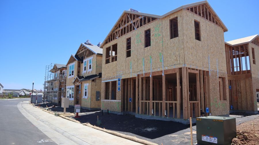 Timber-framed houses under construction on a new residential street