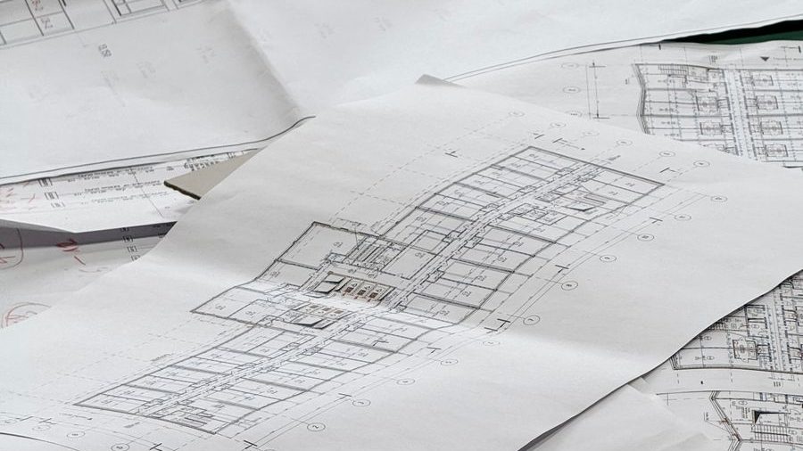 Architectural plans for a new house laid out on a table