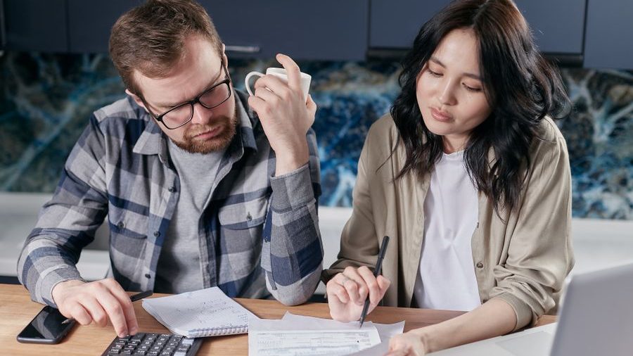 A couple going through their loan paperwork at the kitchen table
