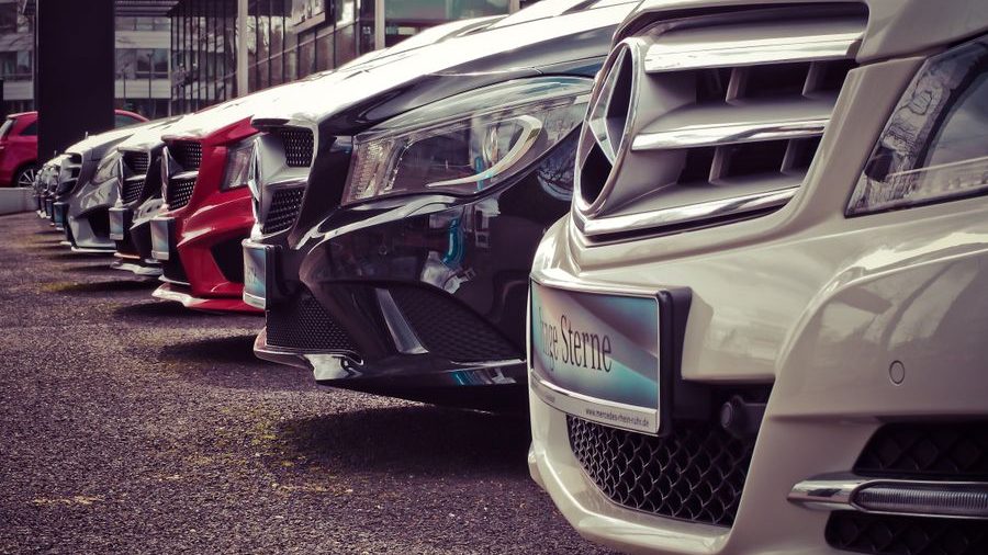 A row of new cars in a dealership showroom
