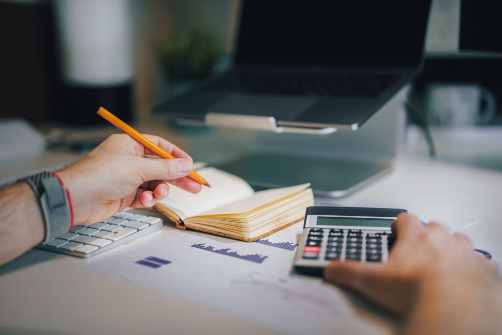 Working out loan repayments with a calculator and notepad